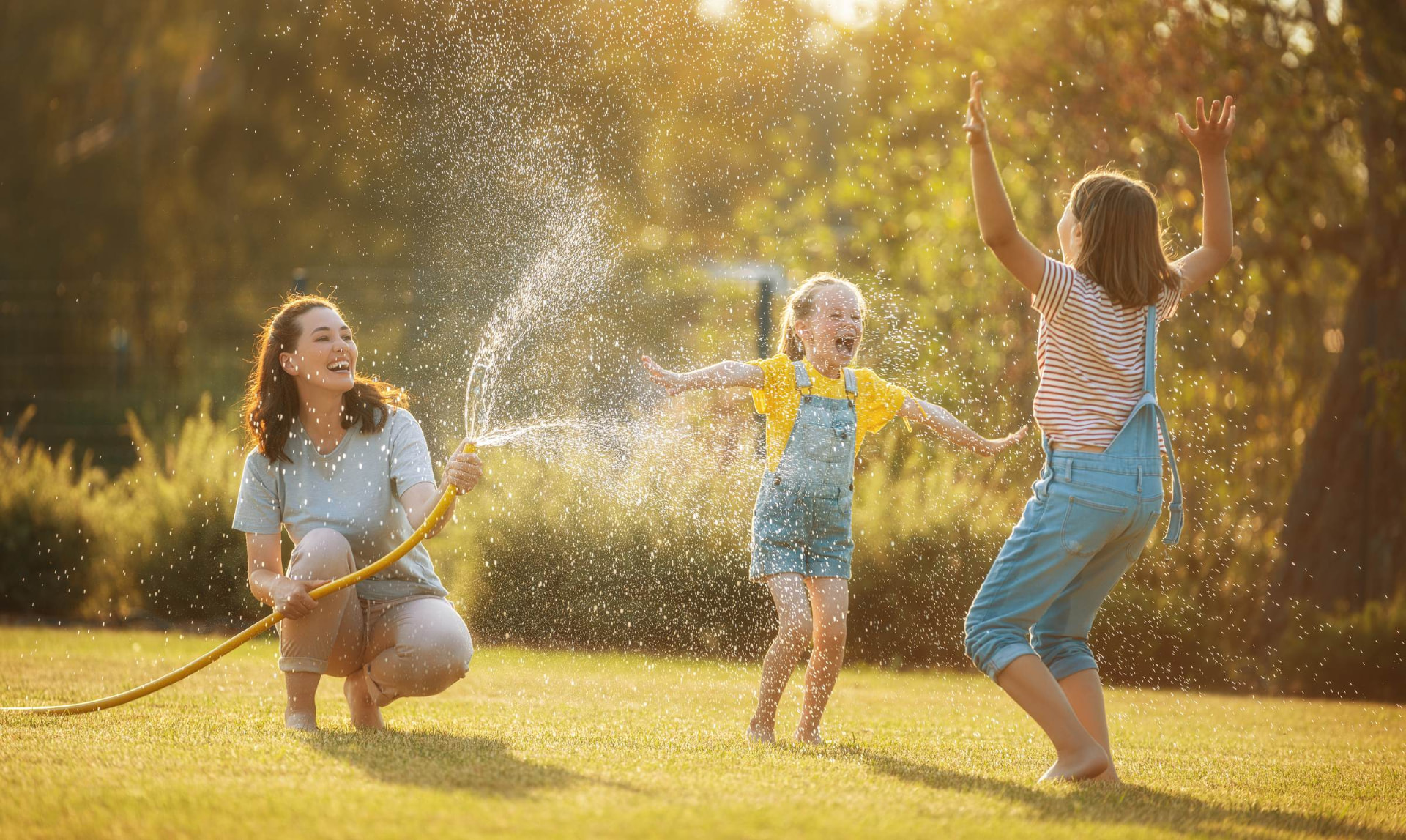 Mutter und Kinder spielen im Sommer auf der Wiese
